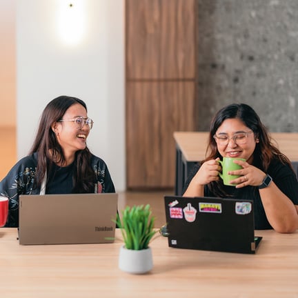 coworkers-smiling-laptops-coffee